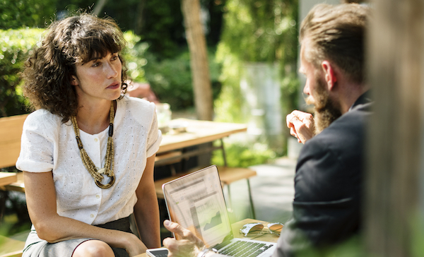 woman in cafe in a meeting with man - Neto ecommerce