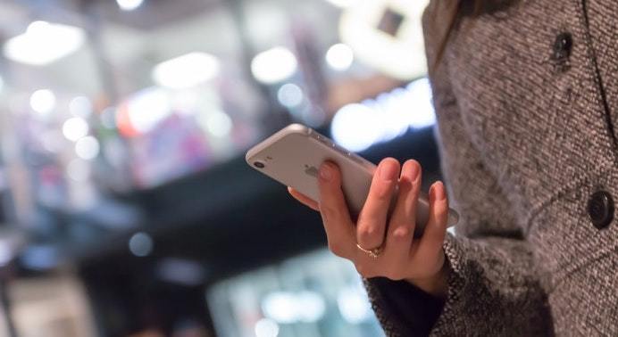 Shopper browses on mobile in shopping mall