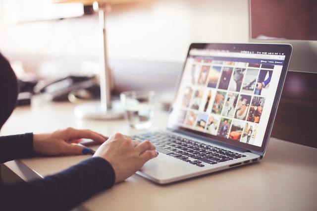 Woman on laptop looking at social media online retail store